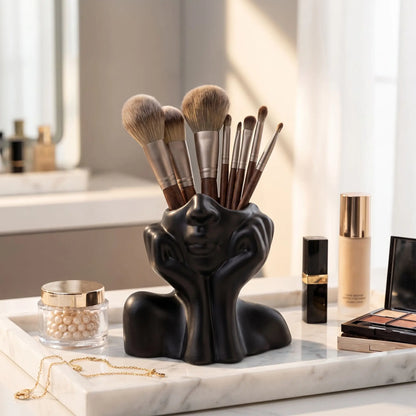 pot à pinceaux maquillage noir mains fermées